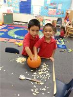 two boys cleaning out pumpkin
