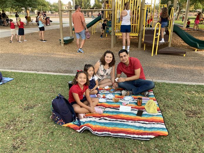  Family sitting on a blanket enjoying breakfast with buddies.