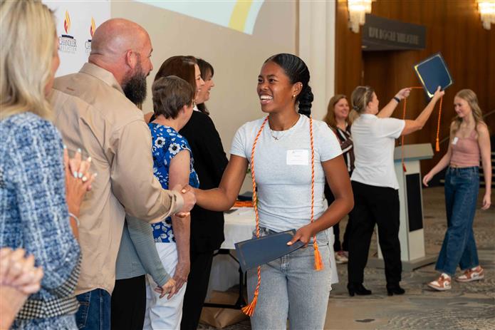  A female student shakes hands with CEF Board Members.