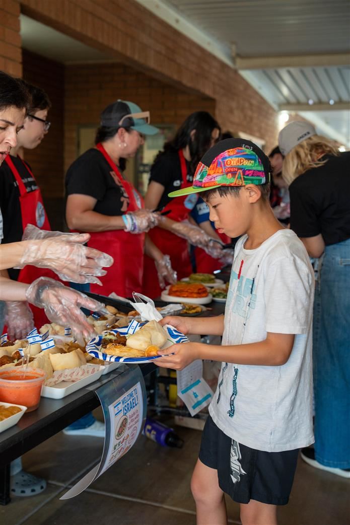 Student trying foods at the Jacobson ELD Potluck picnic
