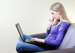 girl in chair with a laptop side view