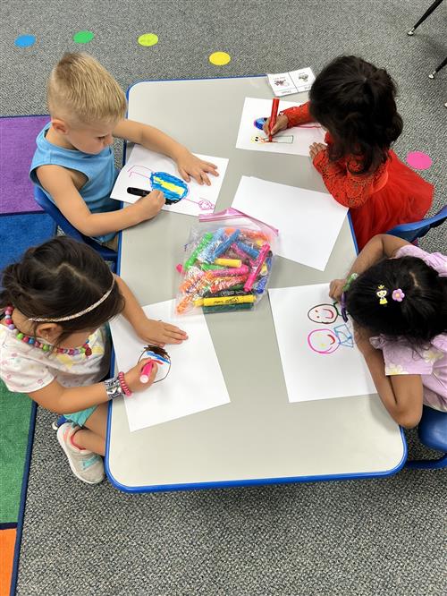 Children coloring in a group during center time at Riggs Preschool Program.