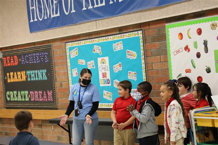  Image of Kids Express staff standing at the front of the room with kids