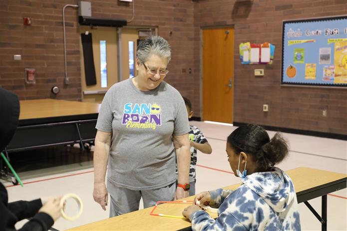 Image of Patti Turner smiling as a kid completes a project