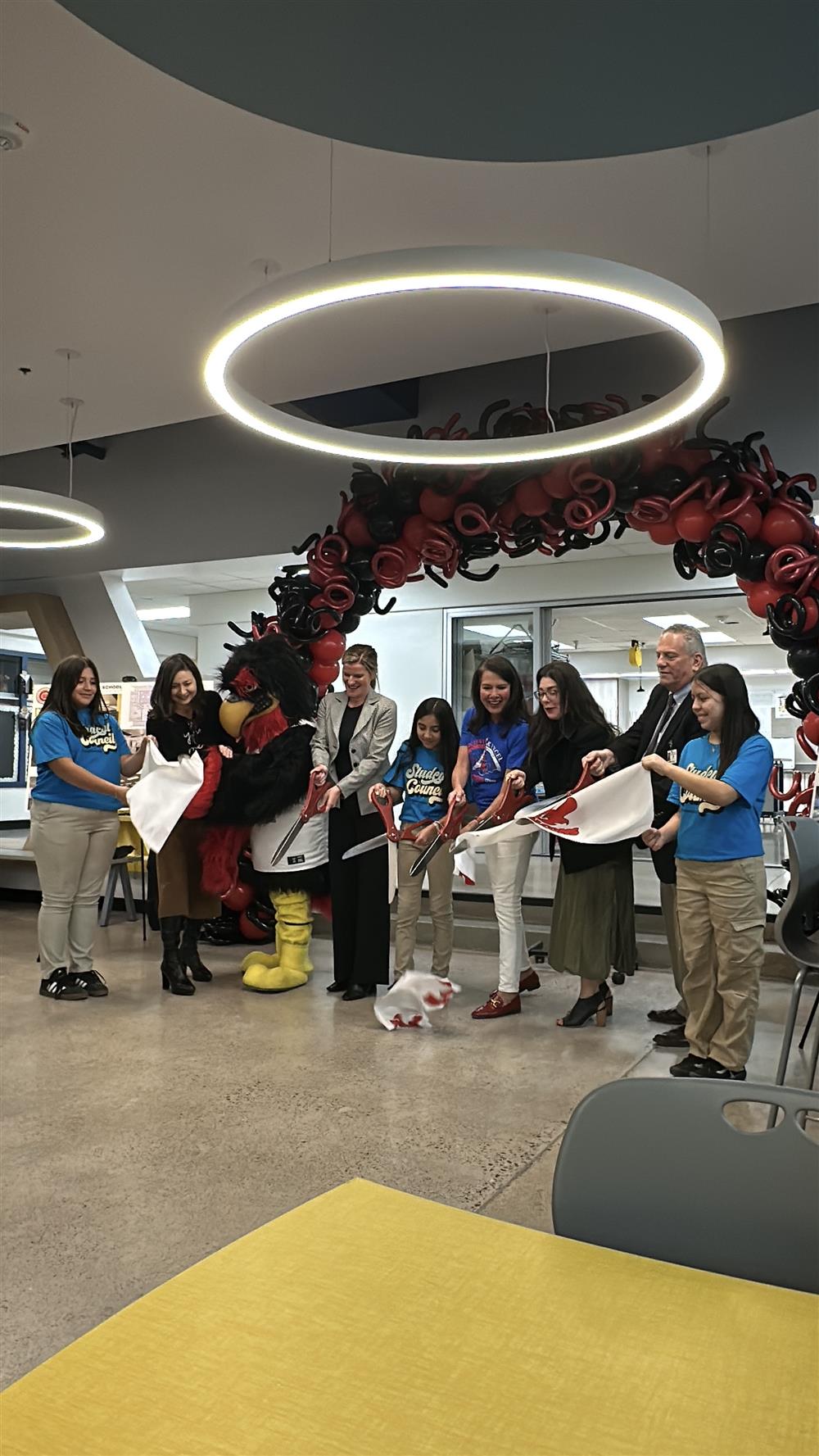An image of CUSD admins, partners, and students cutting a ribbon at a ceremony introducing the community to the new Frye media center.